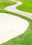 Curved pathway and sand bunker in beautiful green golf cours