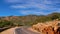 Curved paved road with crash barriers leading through the foothills of Altas Mountains south of Beni Mellal, Morocco.