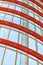 Curved red and white metal structures hold the window systems. Through the glass passes bright sunlight. Illustration of the