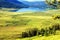 Curved river on meadow and mountain lake