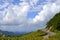 Curved road on green mountain landscape against clear blue sky