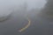 A curved road in heavy fog