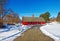 Curved road leading to red barn in Winter snow