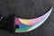 The curved sharp blade of the Kerambit Dagger is a gradient rainbow color on a dark background.