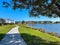 A curved sidewalk next to a lake that is a walking path in back of homes in Laureate Park