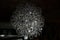 Curved silver wire ball chandelier closeup. Modern metal lampshade. Black and white abstract textured background