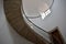 Curved stone staircase with iron handrail, white walls, door and window. Santiago de Compostela, Spain.