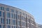 Curved wall of a modern building against the blue sky