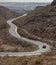 Curved winding road with a red car in the mountains in Gran Canaria