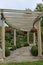 A curved, wood pergola and benches with a stone pathway at the Rotary Botanic Gardens in Wisconsin