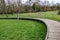 Curved wooden elevated walkway bridge on green grass