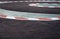 Curving asphalt red and white kerb of a race track detail