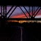 Curving bike trail under a bridge at sunset