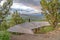 Curving elevated boardwalk descending into valley with tree