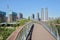 Curving planked footbridge in modern city on sunny summer day