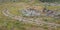 Curving trail on a grassy ground with piled stones