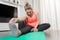 Curvy, blonde Caucasian woman practicing sport at home in a quiet and smiling way