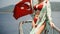 Curvy body woman in a red swimsuit standing on the front of the boat deck and holdin turkish flag on turqouise blue sea