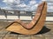 A curvy brown large relaxation chairs on top of a roof