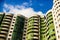 Curvy modern green apartment building under the sunlight and a blue sky