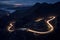 Curvy mountain road with trailing lights at night