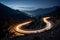 Curvy mountain road with trailing lights at night