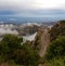 Curvy Mountain Road Winding Around Boulders and forest amoungst Clouds