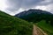 Curvy path with stones in a green mountain landscape while hiking