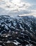 Curvy road and mountain side with snow patches