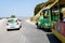 Curvy road with white car and funny excursion train on Rhodes island.