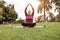 Curvy woman doing yoga meditation while keeping social distance at city park - Focus on face