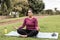 Curvy woman doing yoga session outdoor at city park - Focus on face