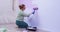Curvy woman paints wall with roller sitting on wooden floor