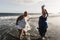 Curvy women dancing on the beach having fun during summer vacation - Focus on left woman