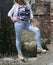 Curvy Young Woman Posing in Blue Skinny Jeans Amidst Historic Ruins on a Sunny Summer Day