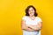 Curvy young woman smiling on a yellow background