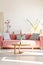 Cushions on red settee and wooden table in living room interior