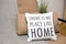 Cushions on a sofa with a text There is no place like home, living room interior design details