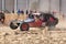 Custom twin seater rally buggy kicking up trail of dust on sand