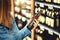 Customer buying beer in liquor store. Lager, craft or wheat beer. IPA or pale ale. Woman at alcohol shelf.