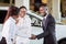 Customer buying a vehicle at car dealership. woman and man handshaking