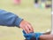 A customer hand places money in a blue hygiene gloved hand worn to avoid transmission and cross infection