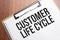 Customer Life Cycle text on white paper on the wood table