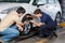 Customer And Mechanic Discussing Over Car Tire