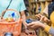 customer paying for items bought in a supermarket with a credit card, black female attendant processing the payment with a mobile