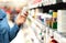 Customer in pharmacy holding medicine bottle. Woman reading the label text about medical information or side effects in drug store