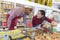 Customer pointing to dish with sales assistant at deli counter