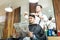 Customer Reading Newspaper While Barber Cutting His Hair