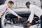 Customer and salesman opened the car hood and discuss all the nuances concerning the car