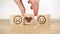 Customer satisfaction concept. Smiley and sad face icon on a wooden cube, hand shaking. Service rating, review or survey